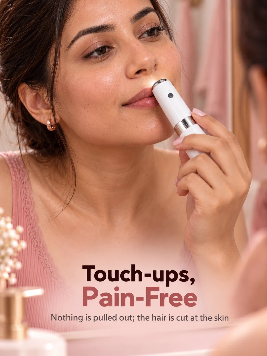 A woman touching up her upper lip with the Mini Hair Remover at the mirror, its light on